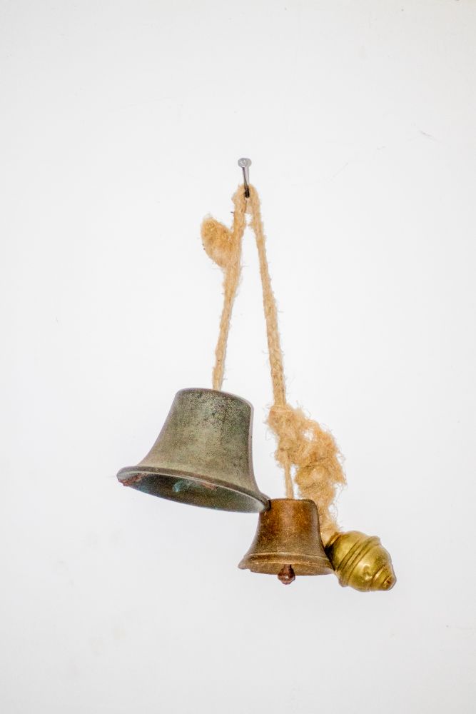Three cast bells hanging from a fibre cord