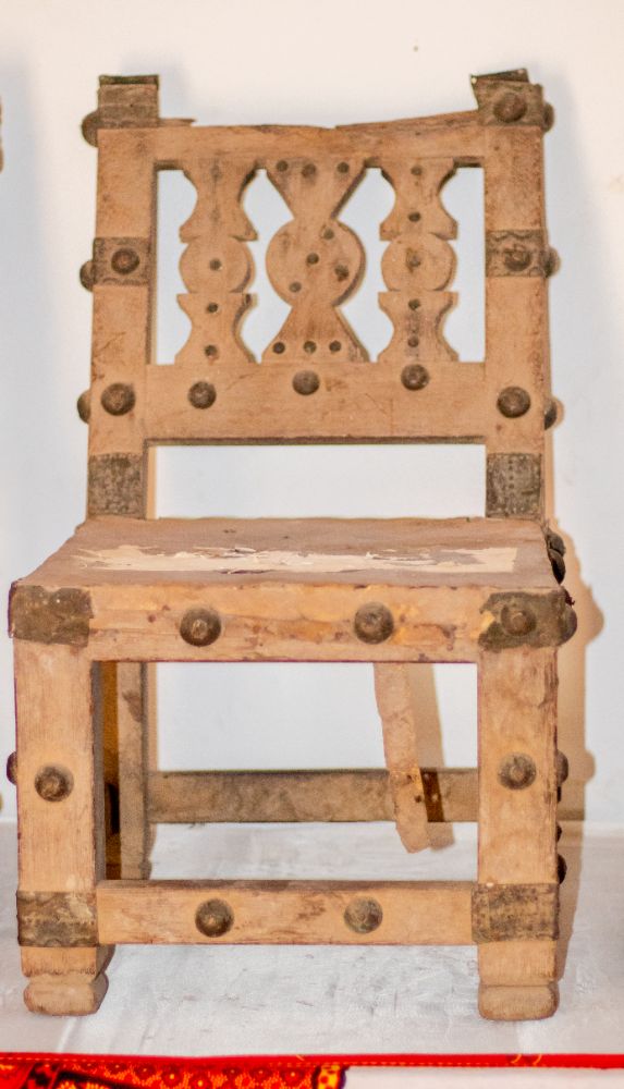 A wooden chair with carved back splat and brass corner plates