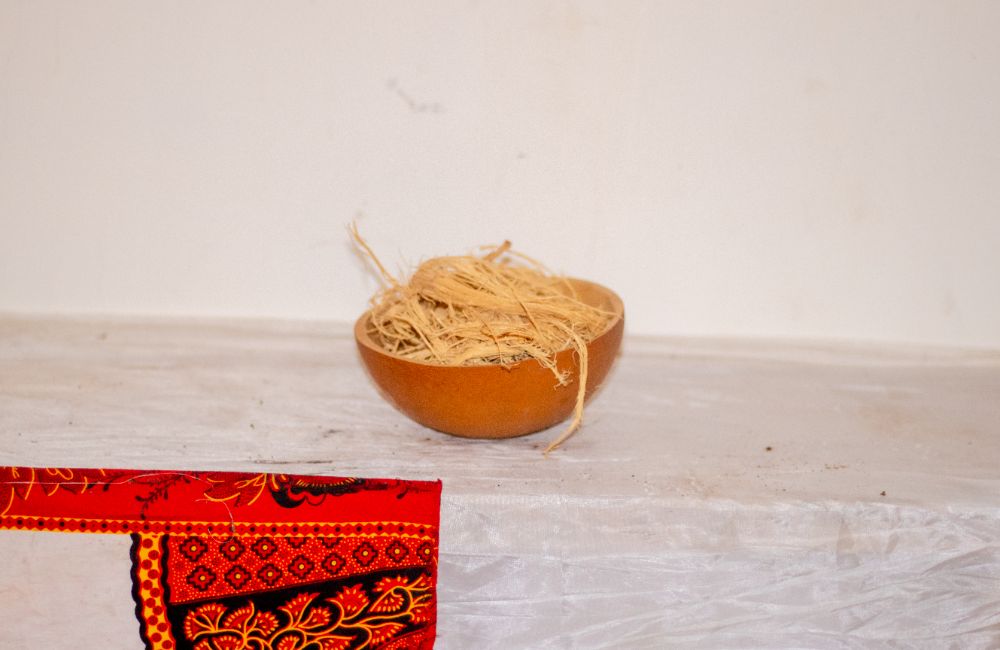 A gourd bowl filled with raffia fibre