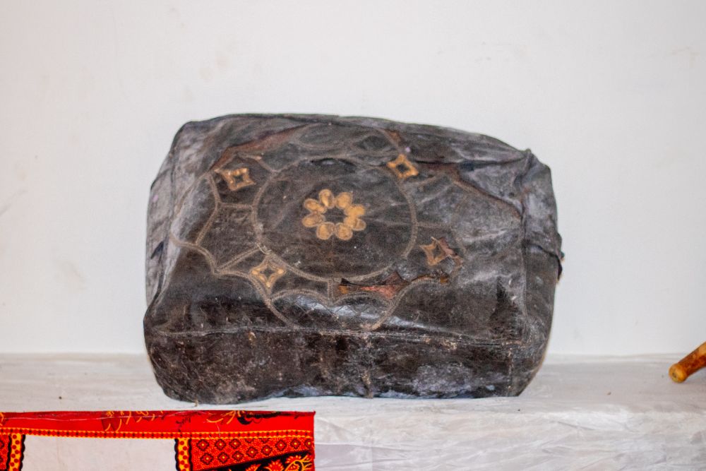 A dark leather box tooled with a gold rosette motif