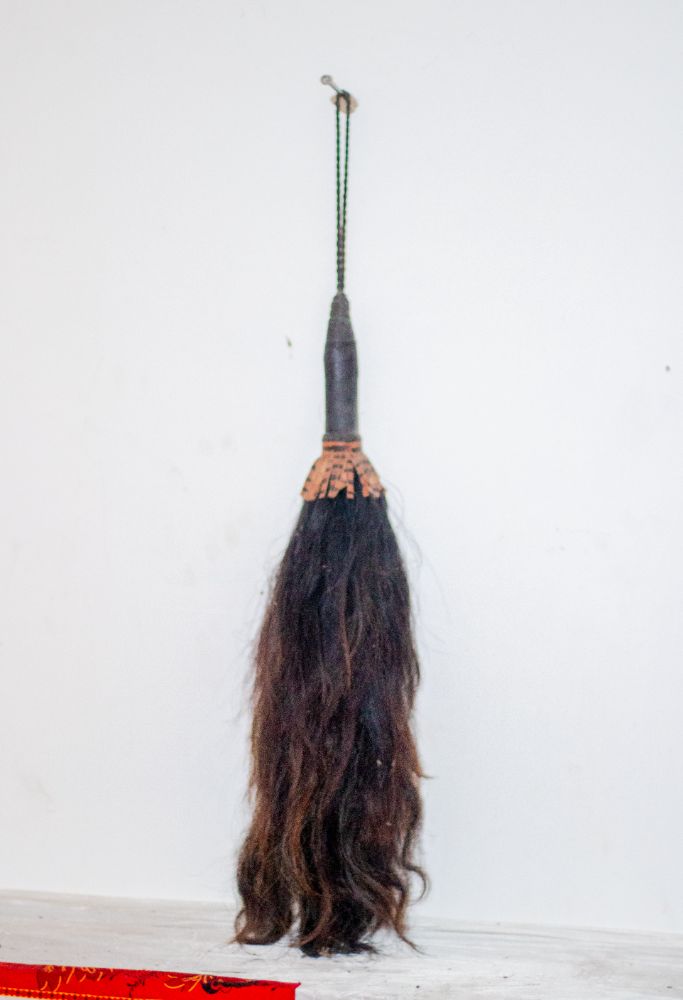 A horsetail whisk with a carved and beaded handle