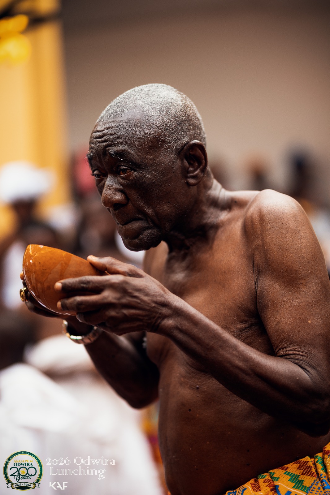 An elder raises a carved bowl to drink during the Odwira launch ceremony