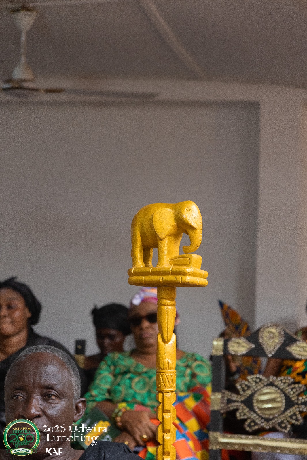 A carved gold elephant finial atop a linguist staff